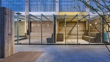 Un edificio moderno con entrada de vidrio, interior de madera y pared de piedra.