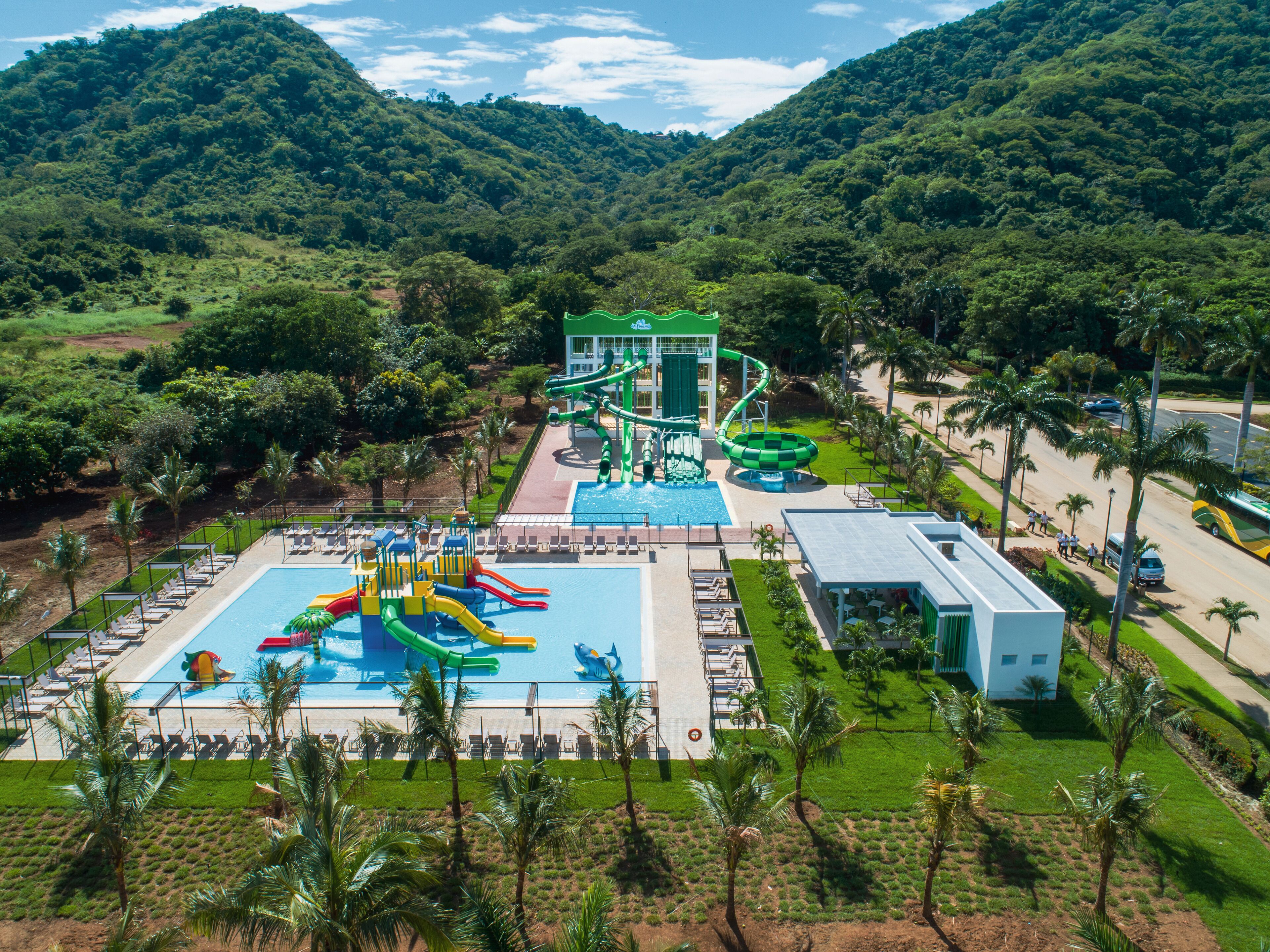 Un resort con piscina, toboganes acuáticos y un edificio de techo verde.