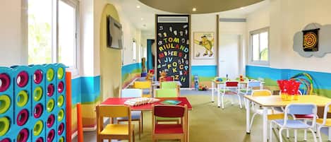 Un aula luminosa con mobiliario colorido y decoración educativa.