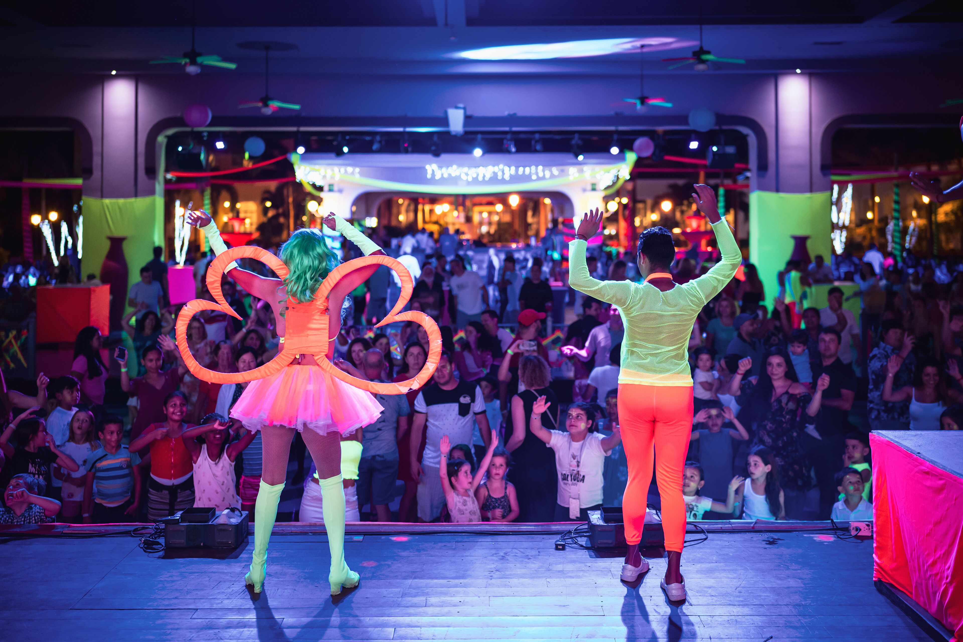Un evento multitudinario en interiores con un escenario y un público.