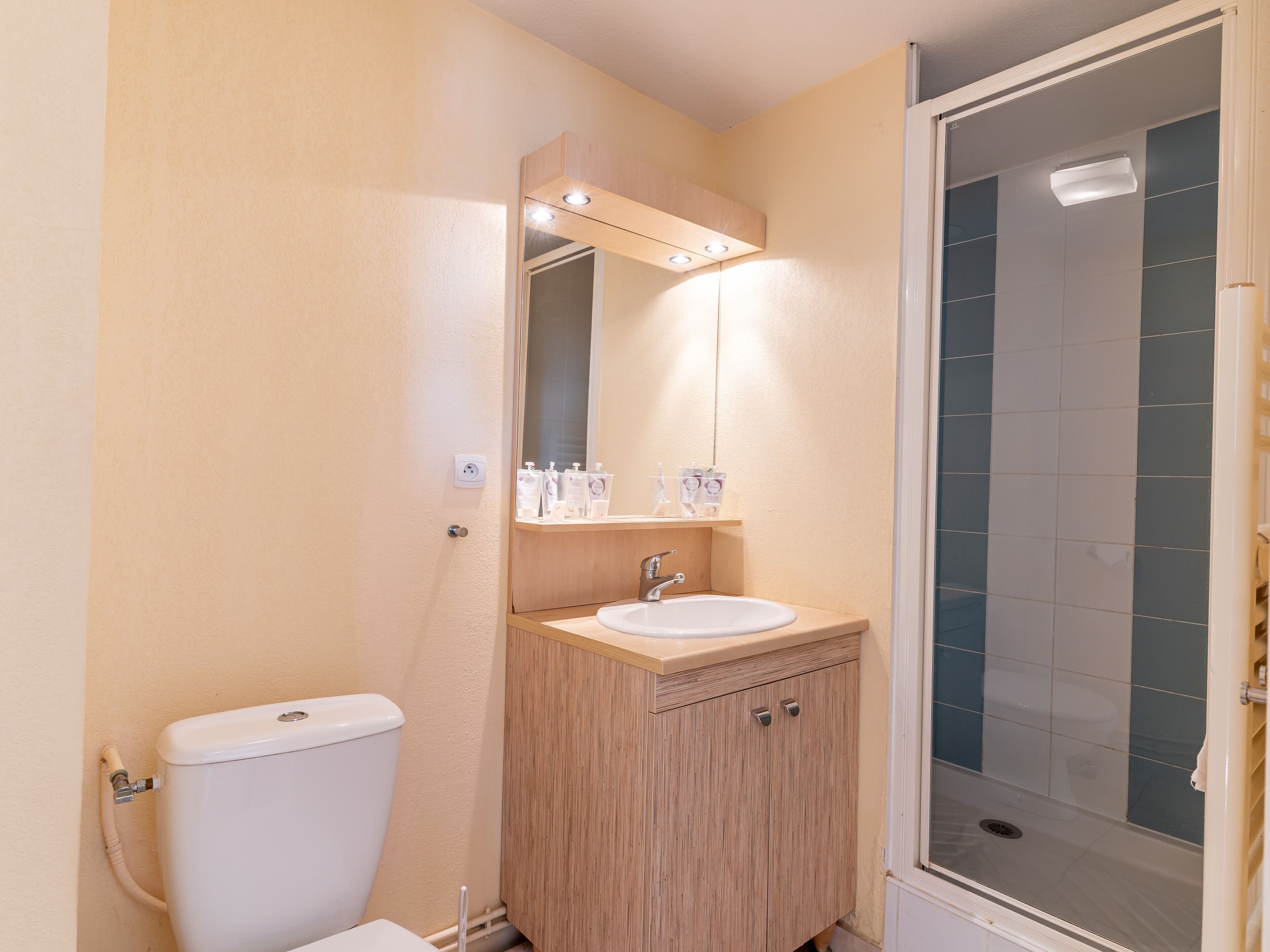 A bathroom with a toilet, sink, and shower.