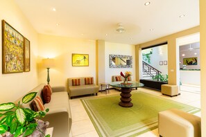 A spacious living room with a sofa, a coffee table, and a staircase leading to another area.