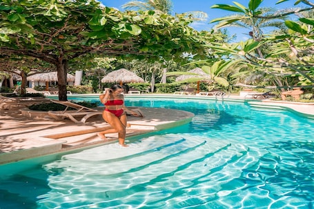 Una piscina al aire libre, camas de piscina gratis, sombrillas