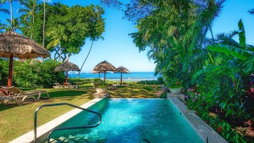 Una piscina al aire libre, camas de piscina gratis, sombrillas