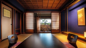 Una habitación tradicional japonesa con suelo de tatami, una mesa baja y puertas correderas shoji.