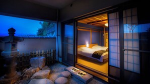 Una habitación japonesa tradicional con suelo de tatami, un futón y una puerta corredera de shoji.