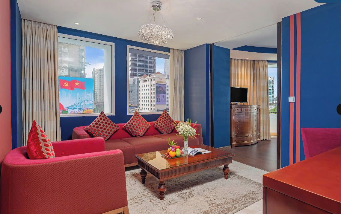 A modern living room with a sofa set, a coffee table with fruit, and a television.