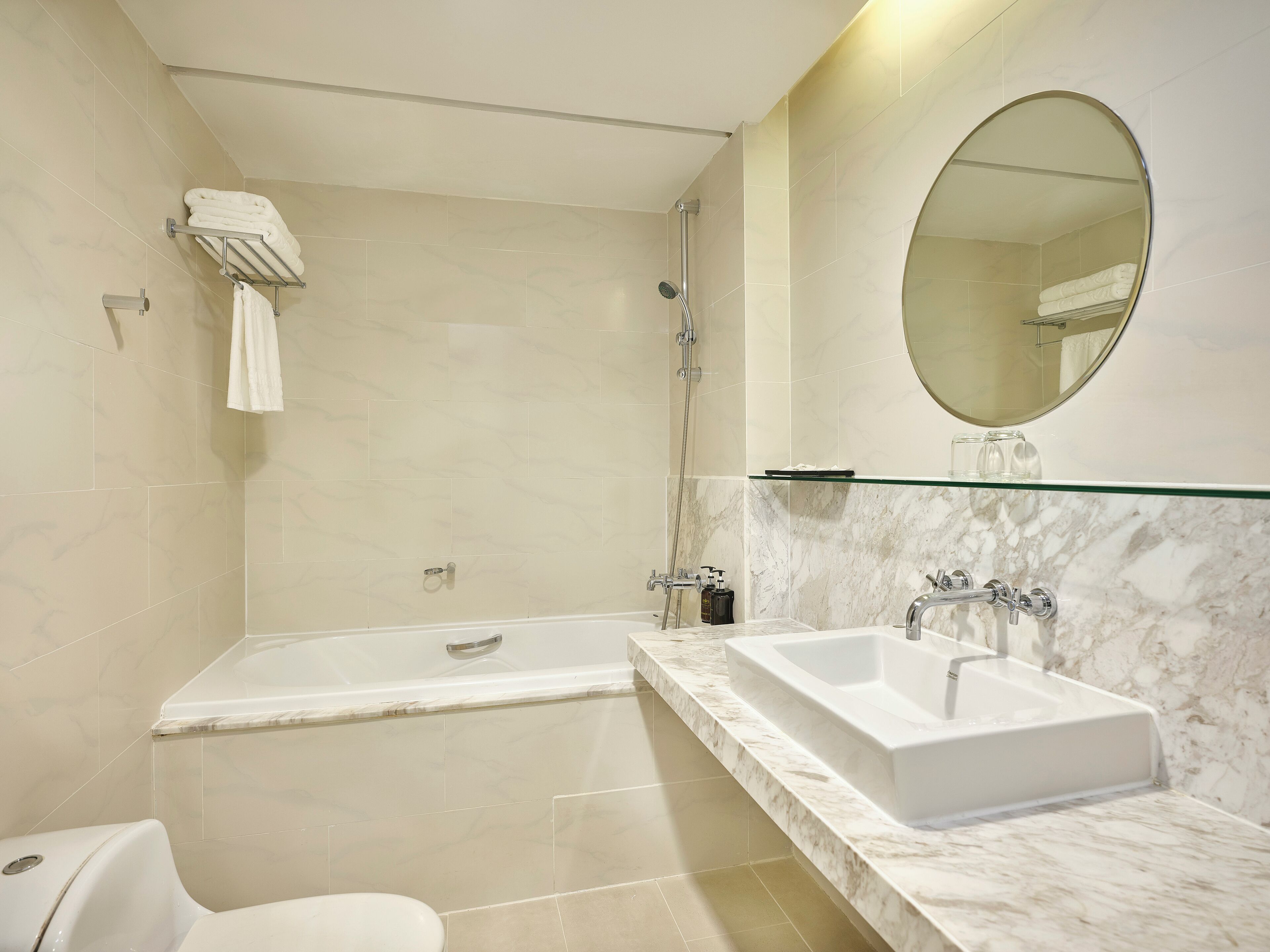A modern bathroom with a bathtub, a sink, and a toilet.