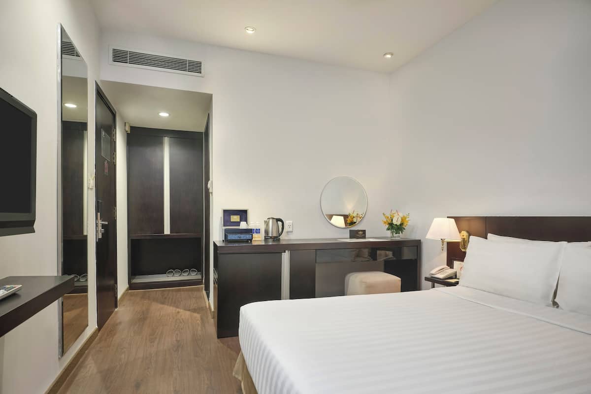 Ein Hotelzimmer mit Bett, Schreibtisch und Kleiderschrank.