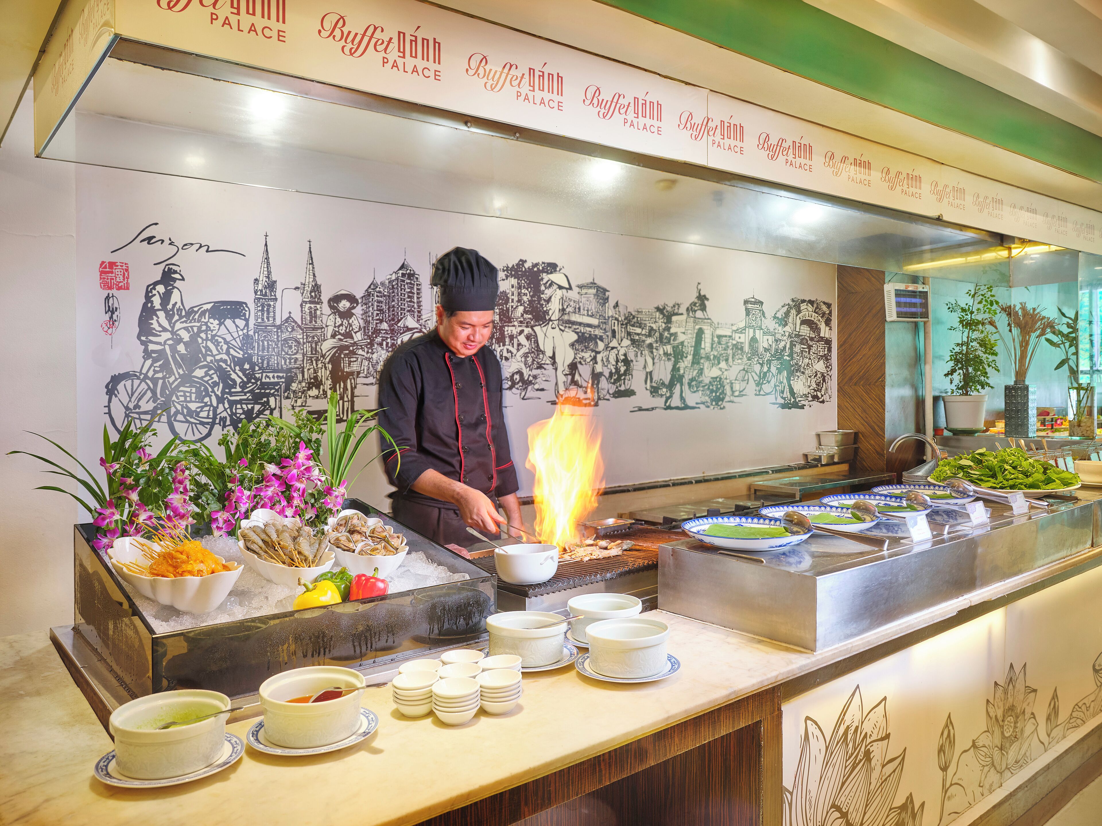 A buffet area with a chef preparing food, a variety of dishes, and a decorative wall with illustrations.