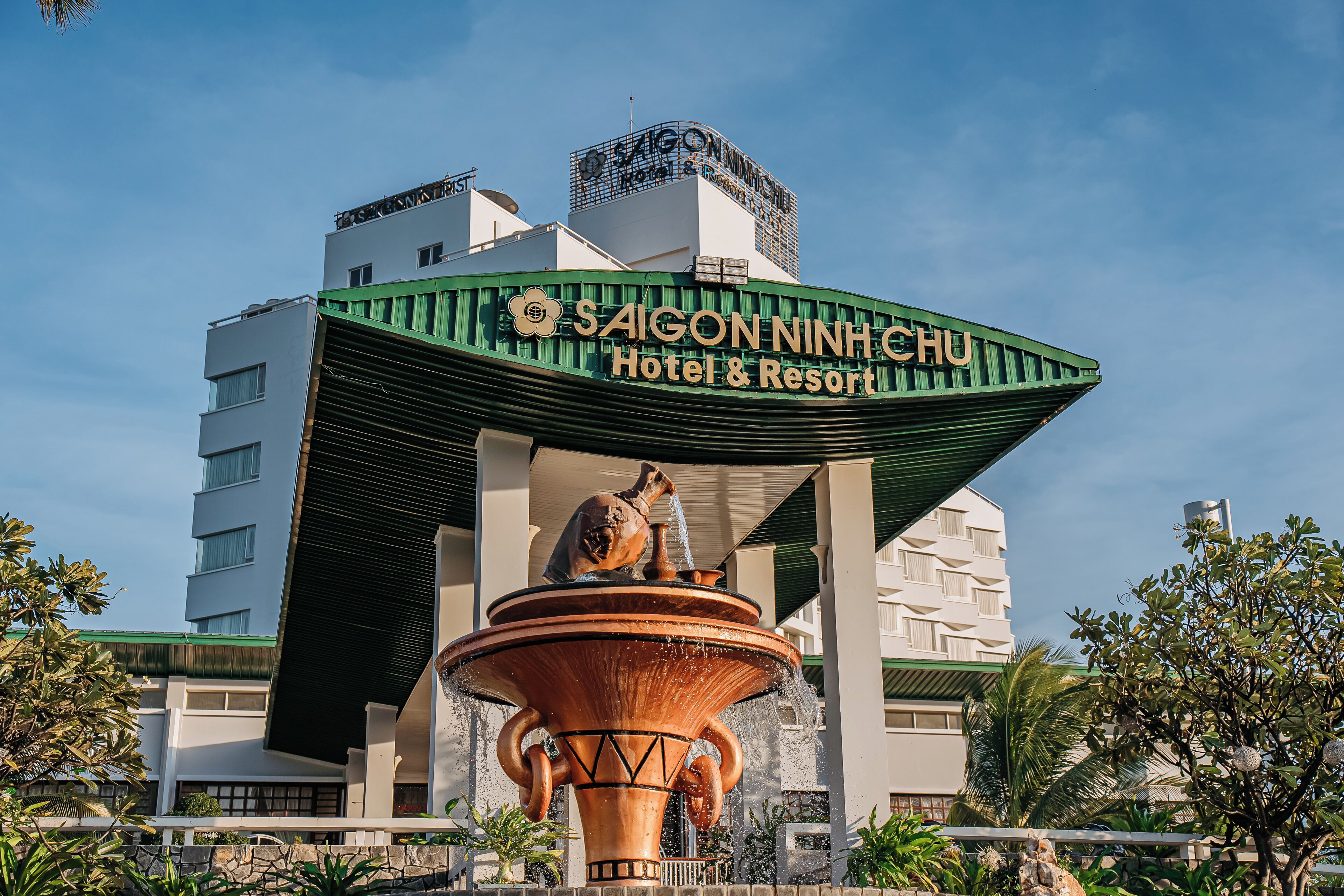 A building with a green roof and a sign reading "SAIGON NINH CHU Hotel & Resort".