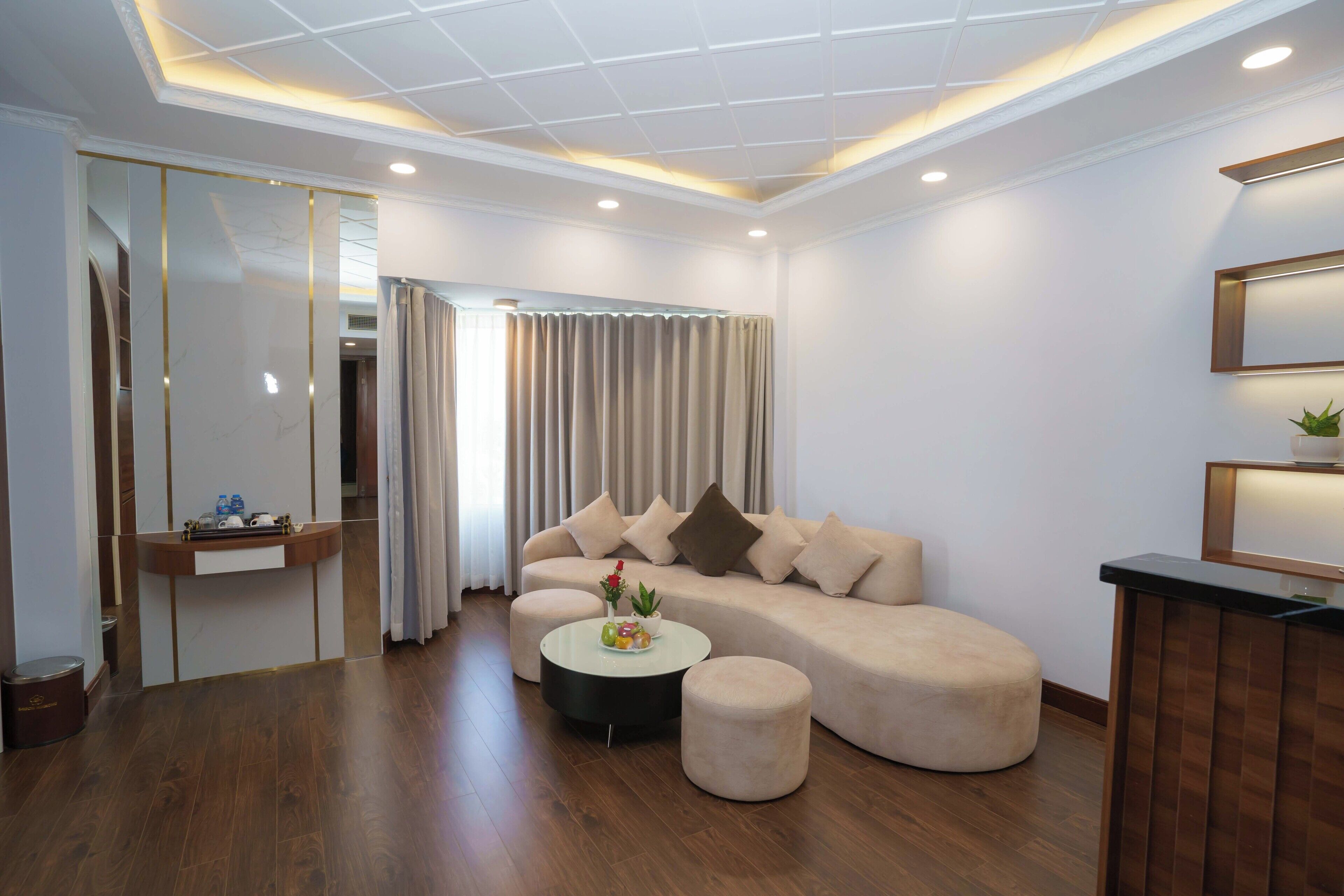 A modern living room with a sectional sofa, a round coffee table, and a small side table.
