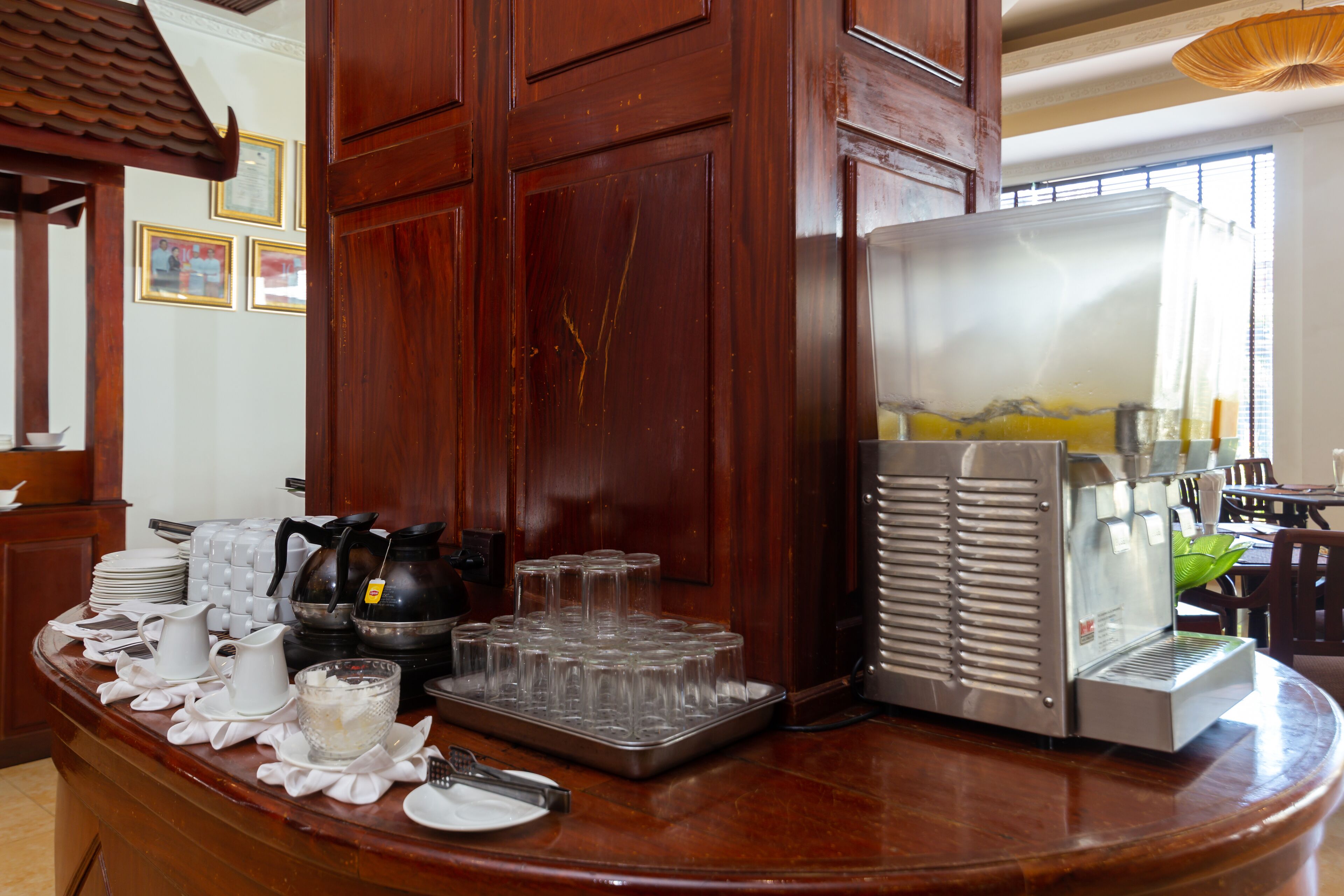 Una barra de desayuno con cafetera, hervidor de té y dispensador de bebidas.