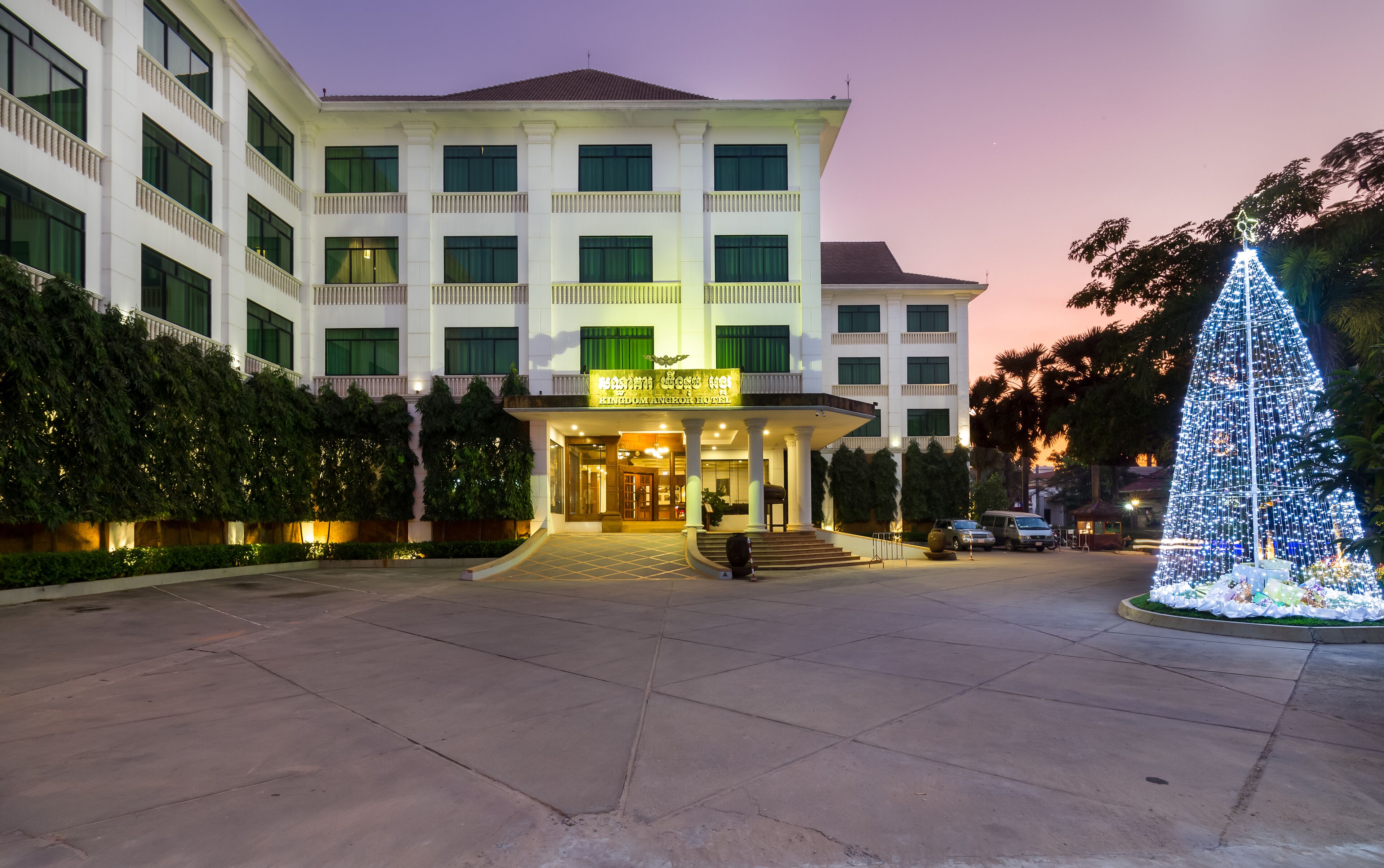 Un hotel con un vestíbulo amplio, varios pisos y una fachada bien iluminada.