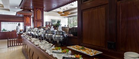 Uma mesa de buffet com diversos alimentos e utensílios de servir.