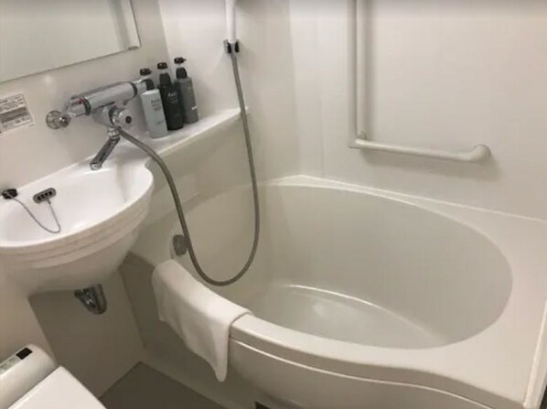 Un baño con lavamanos blanco, bañera y ducha.