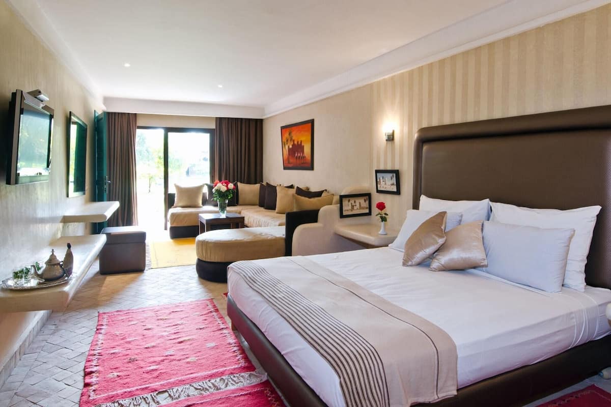 Una habitación de hotel con una cama grande, un sofá, un escritorio y una silla.