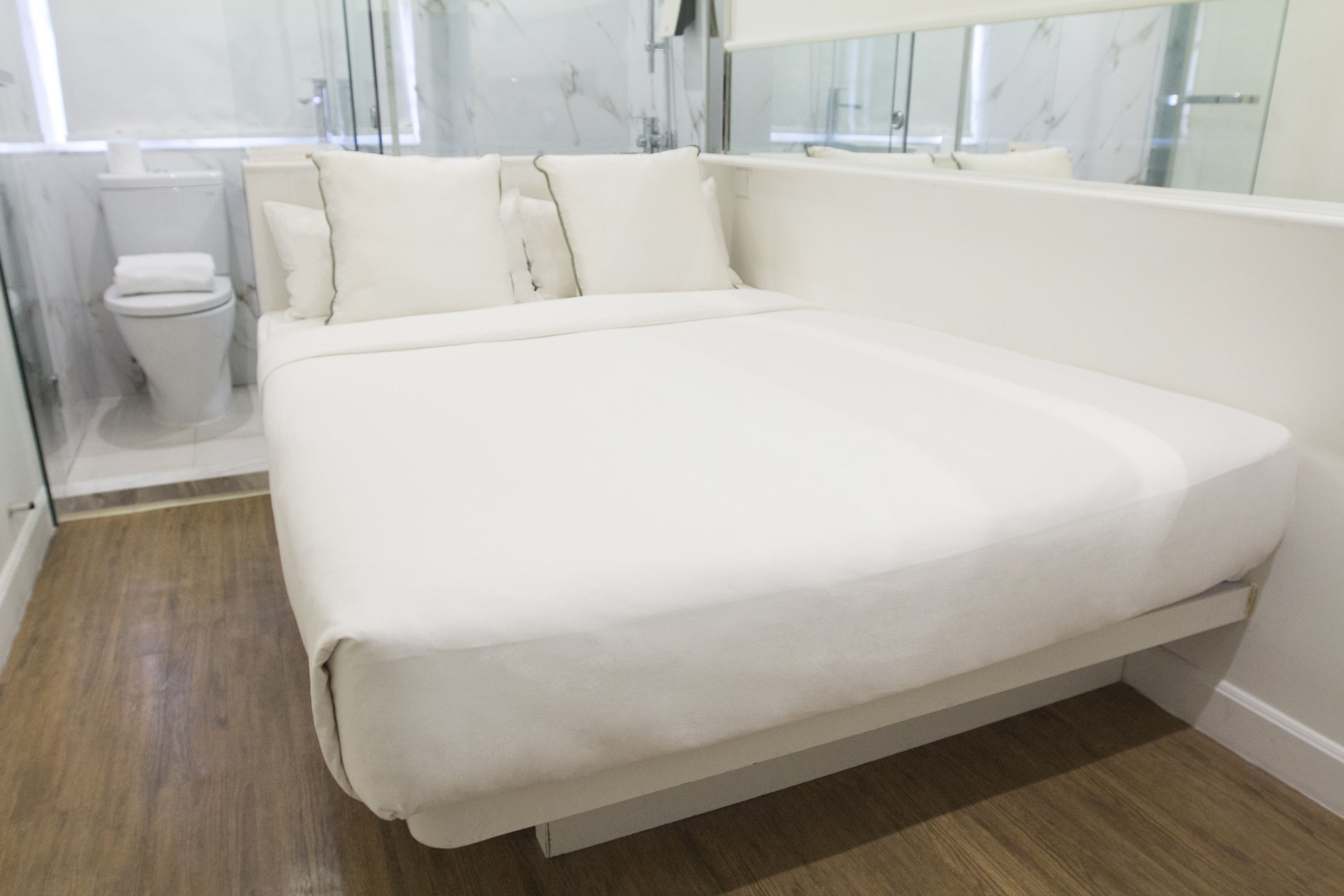 A modern bathroom with a white bathtub, a toilet, and a glass shower enclosure.