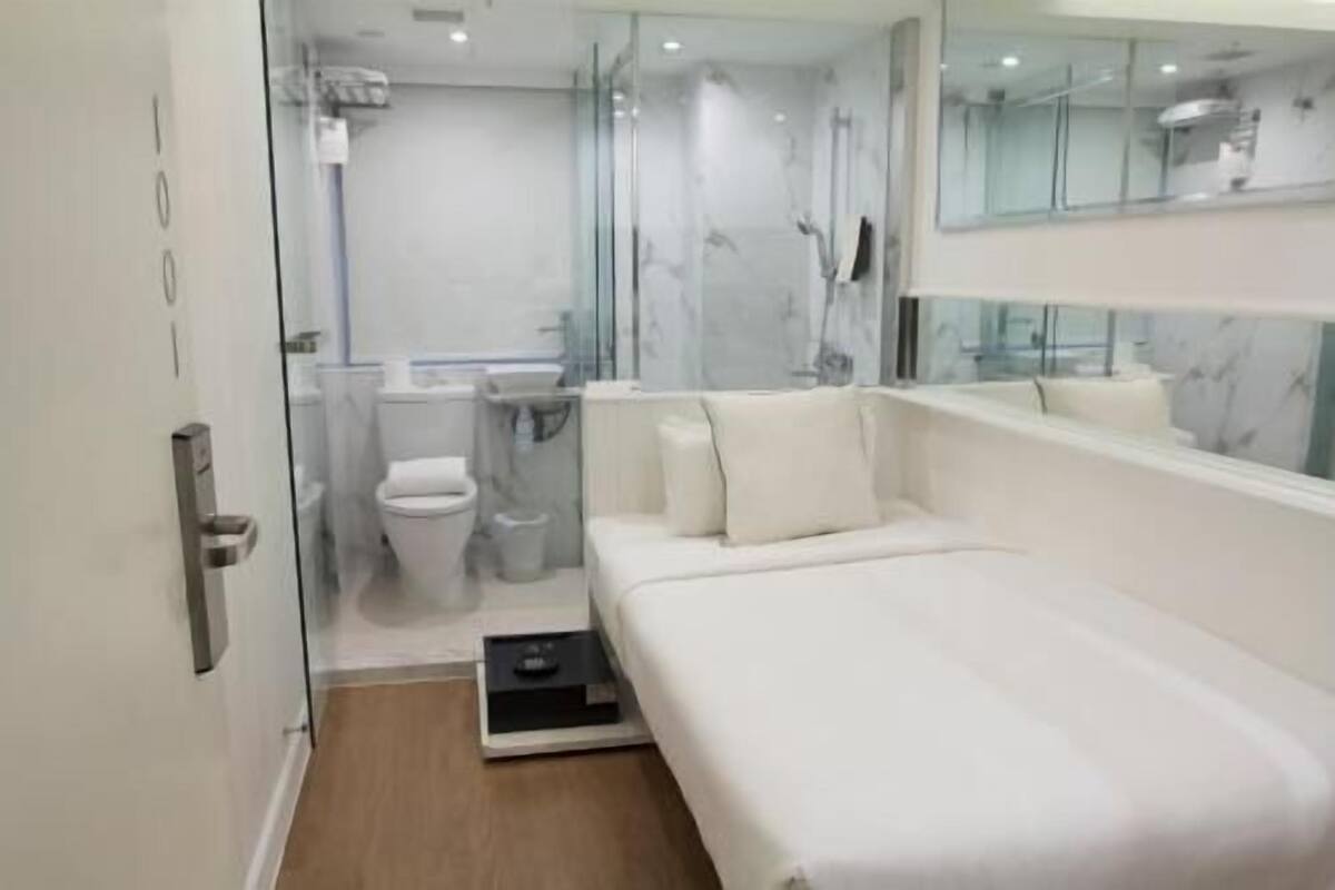 A modern bathroom with a glass shower enclosure, a toilet, and a sink.