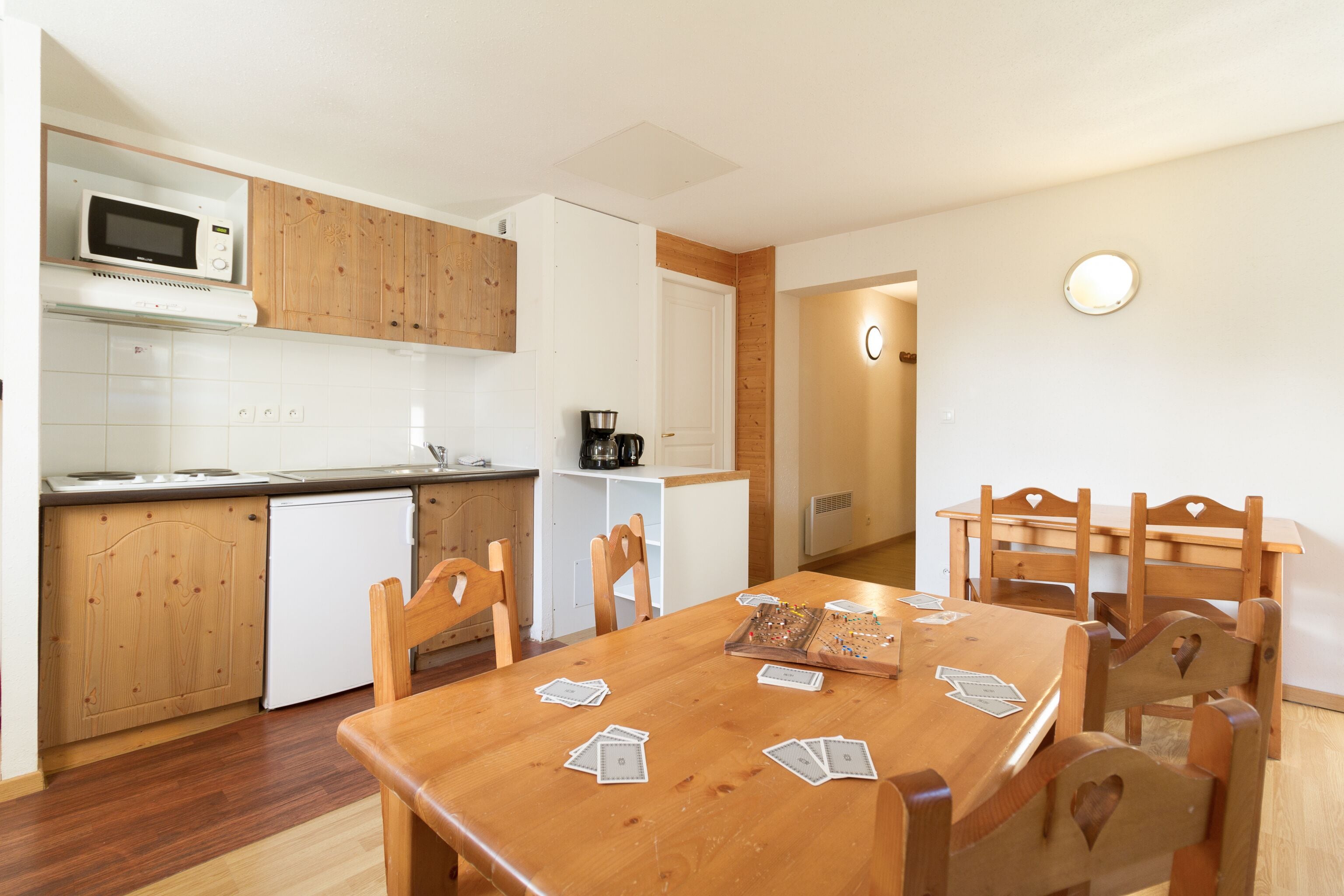 A compact kitchen with wooden cabinets, a microwave, and a coffee maker.