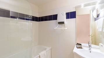 A bathroom with a bathtub, a sink, and a mirror.