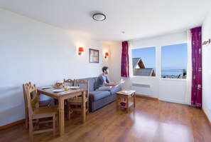 Apartamento superior | Área de estar | TV de tela plana 90 cm com canais digitais, TV