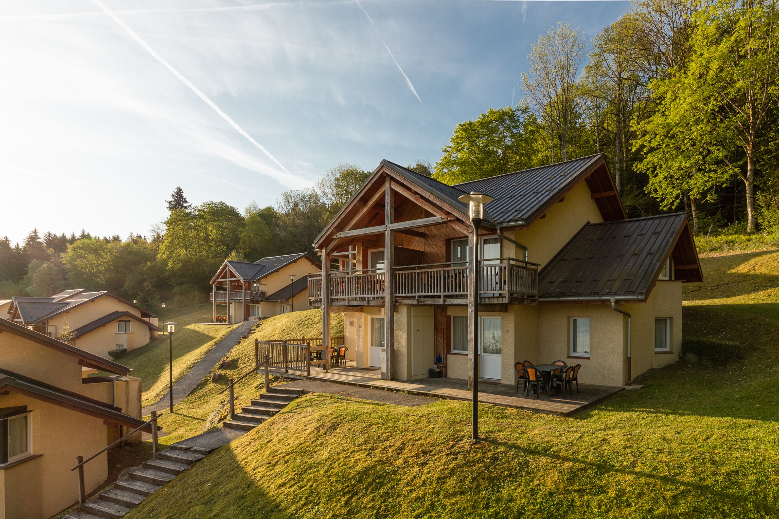 Ein Wohngebiet mit Häusern, die hölzerne Balkone besitzen, und einem zentralen Gebäude mit einer Veranda.