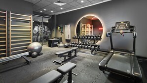 A gym with treadmills, dumbbells, benches, and exercise balls.