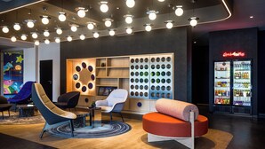A modern lobby with a seating area, a wall with circular patterns, and a neon sign.