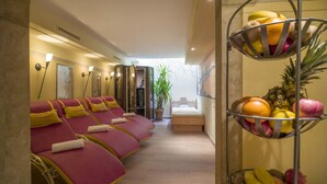 A spa room with red massage chairs, a wooden bench, and a fruit basket. - Loipenstub'n (Brixen im Thale)