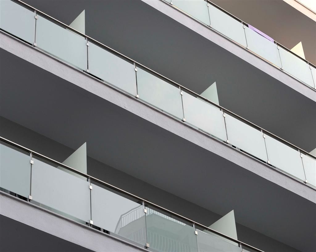 A multi-story building with balconies and large windows.