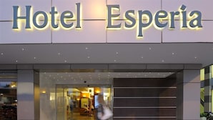 Een moderne hotelentree met een groot, verlicht bord waarop 