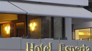 Une enseigne d’hôtel portant le nom « Hôtel Esperia » est illuminée.