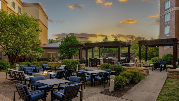 An outdoor patio area with tables and chairs, a fire pit, and a pergola. - Homewood Suites by Hilton Pittsburgh Southpointe (Canonsburg)