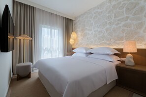 Relax in a spacious room with a large bed, flat-screen TV, and comfortable seating area.