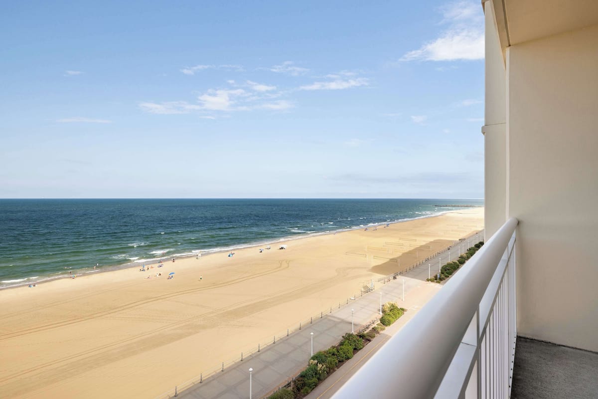 A beach view from a balcony with a clear sky.