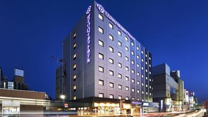 Hotel Daiwa Royal com design moderno, vários andares e uma sinalização marcante.