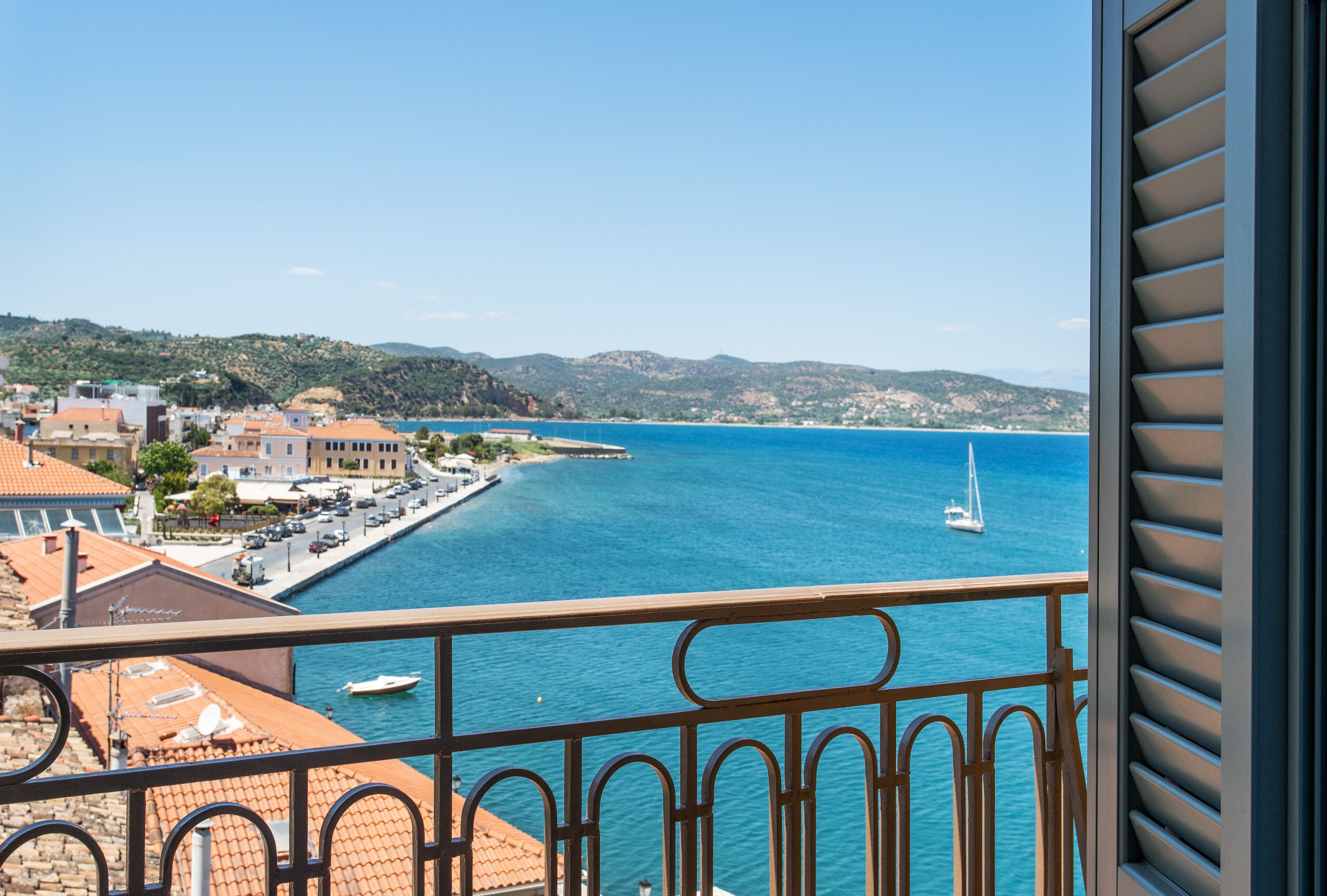 A coastal town with a marina, buildings along the waterfront, and a clear view of the sea.