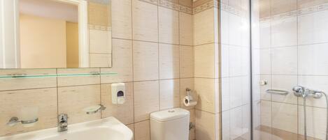 A bathroom with a sink, toilet, and shower.