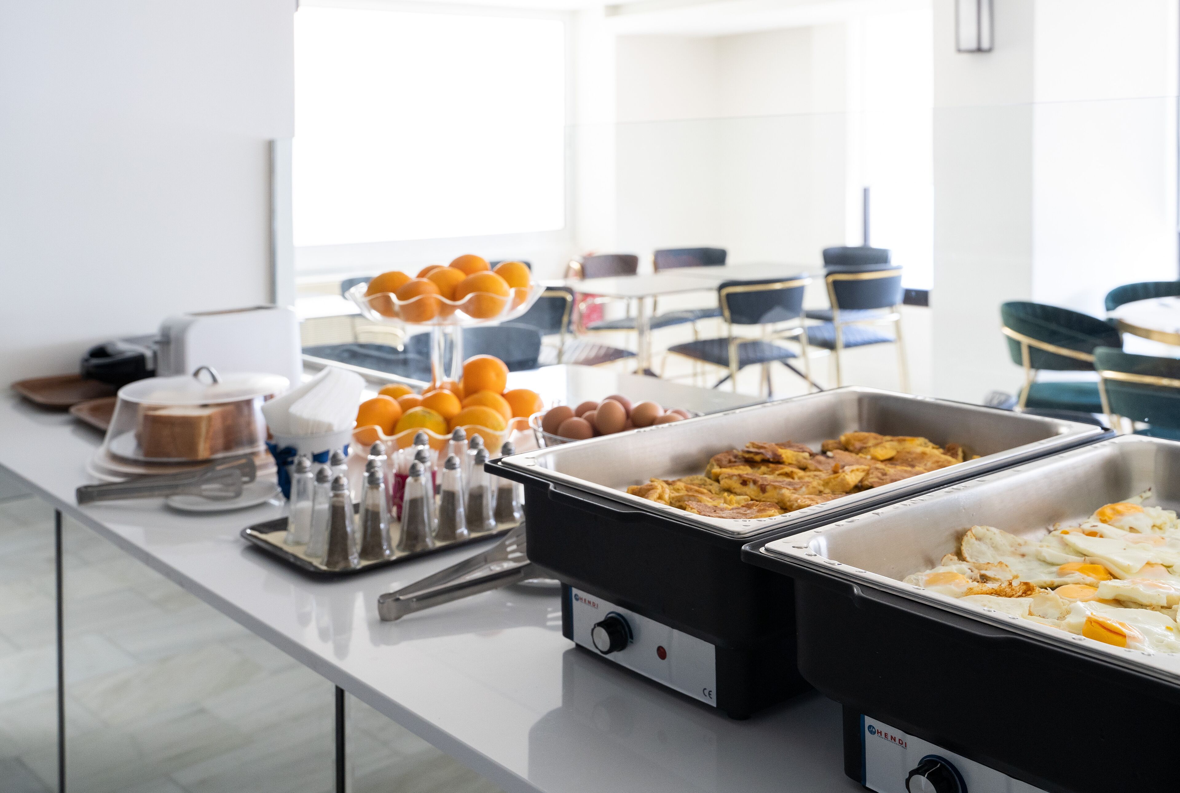 A buffet setup with various food items and condiments.
