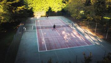Una cancha de tenis rodeada de árboles.