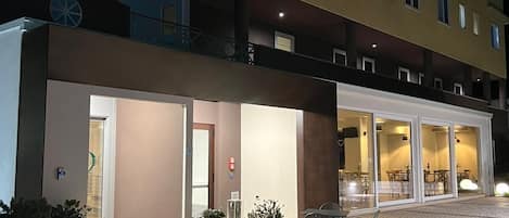 Un hotel de diseño moderno, con un amplio espacio exterior que incluye un patio empedrado y mobiliario.