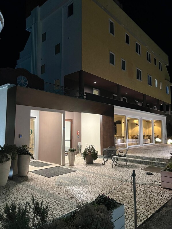 Un hotel de diseño moderno, con un amplio espacio exterior que incluye un patio empedrado y mobiliario.