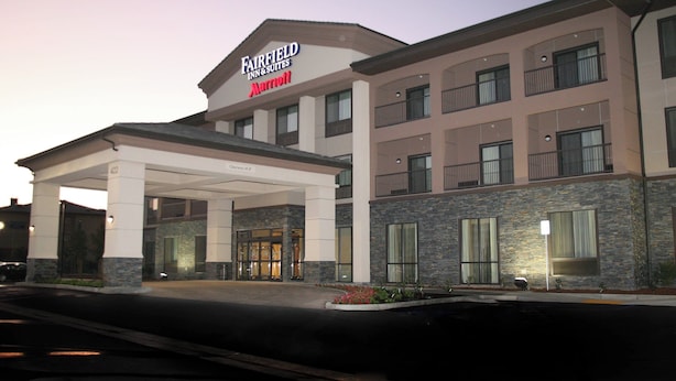 Un hotel Fairfield Inn & Suites by Marriott con entrada cubierta y fachada de piedra.