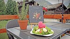 Une table avec une assiette de nourriture, une plante en pot et un menu.
