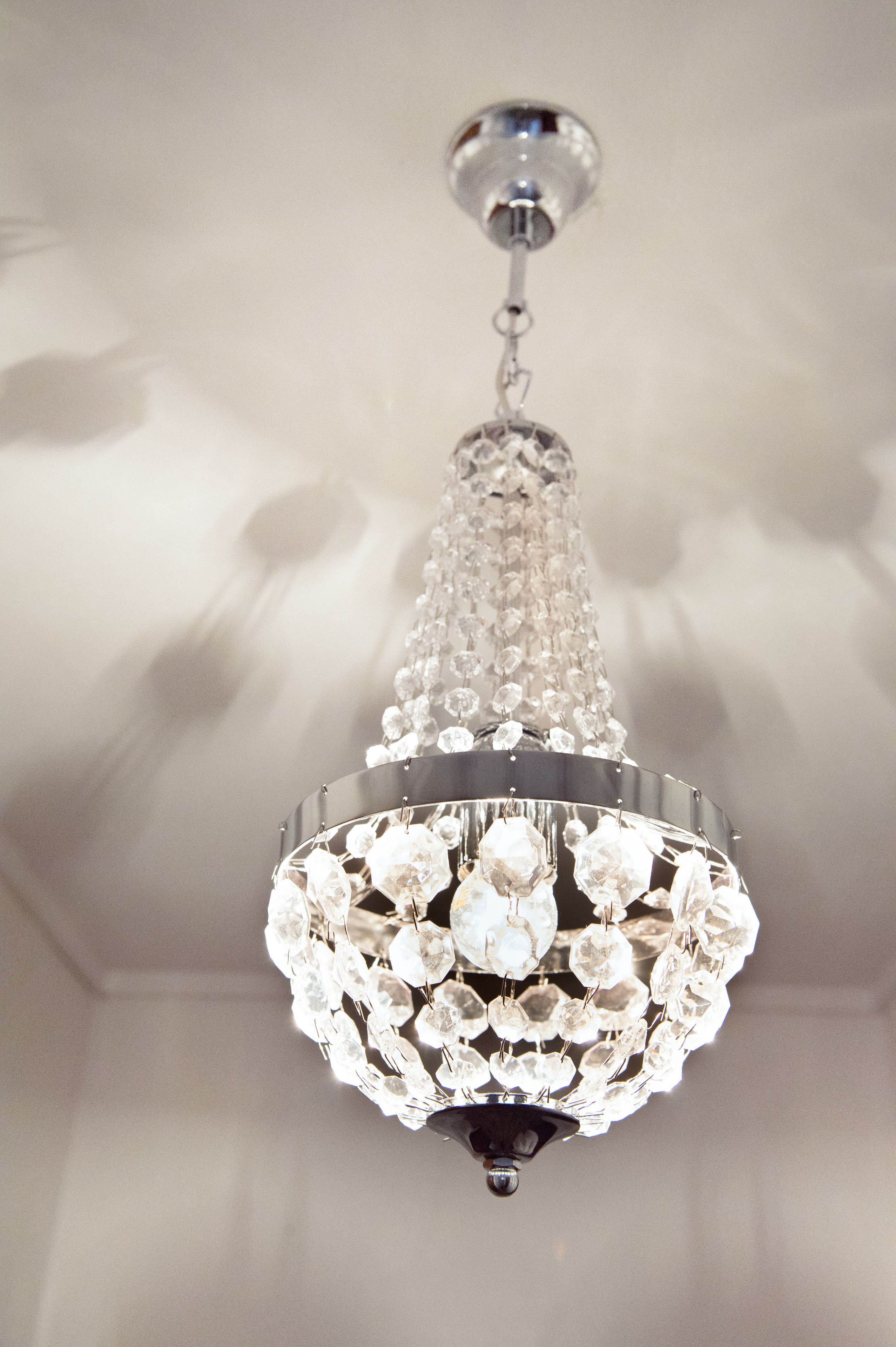 A chandelier with multiple crystal elements hanging from a metallic structure.