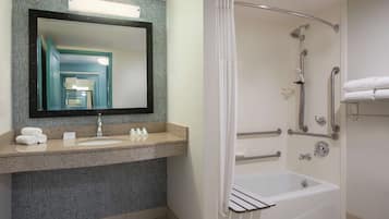 Un baño moderno con lavabo, espejo, ducha y bañera.