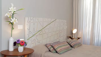 Une chambre à coucher avec un lit, une table de chevet et un mur orné d’un motif géométrique.