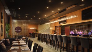Un restaurant doté d’un bar, d’une décoration en bois et d’un escalier menant à un étage supérieur.