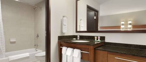 A modern bathroom with a bathtub, toilet, and sink.